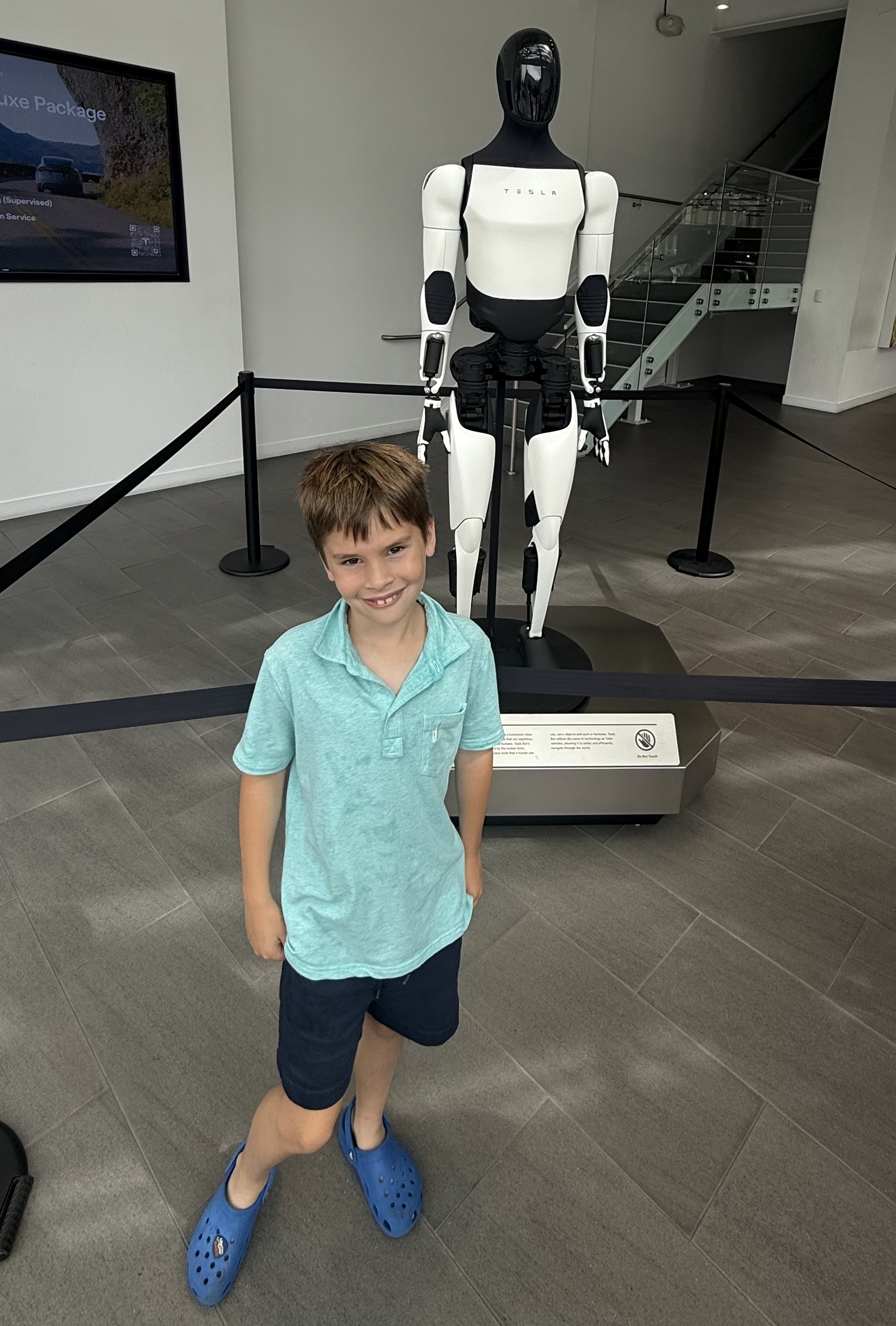 Luke standing in front of a Tesla Optimus robot