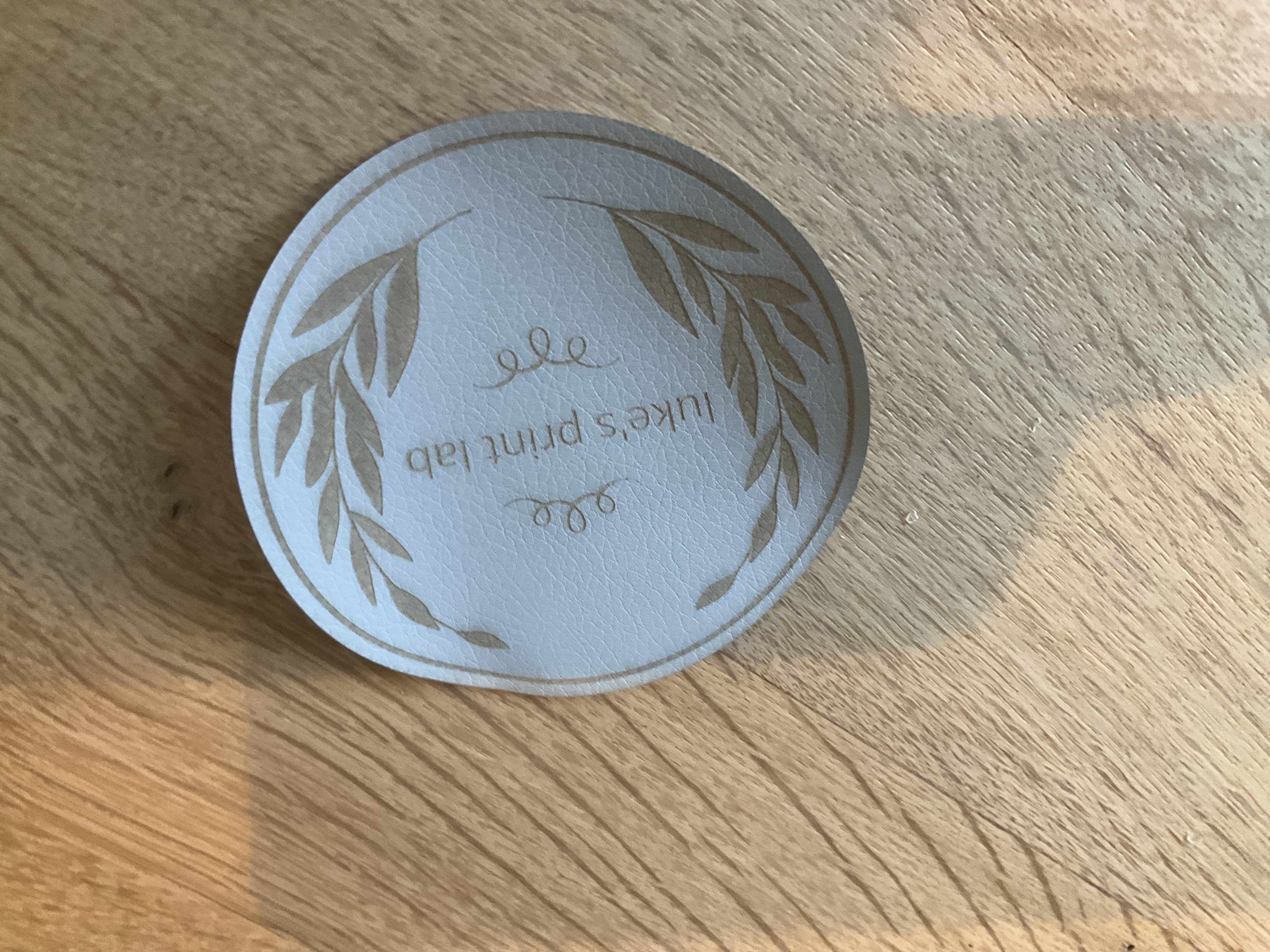 Laser engraved Luke's Print Lab leather coaster
